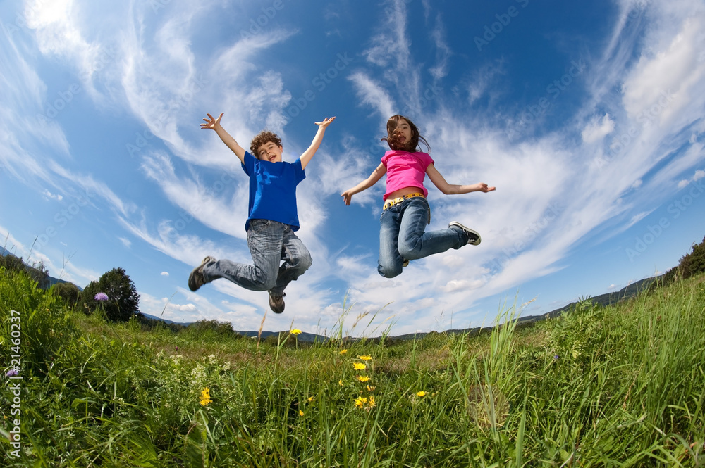Girl and boy jumping, running against blue sky Girl and boy jumping, running against blue sky