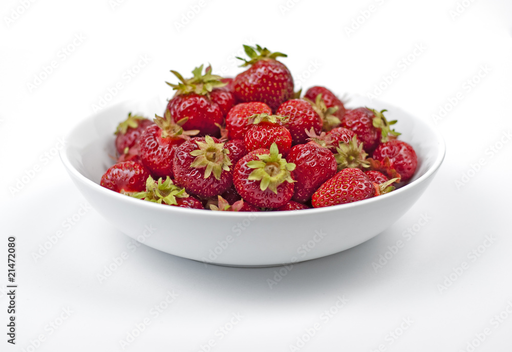 A white plate full of strawberries on white background. A white plate full of strawberries on white background.
