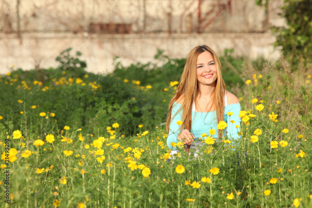 Beautiful young woman sitting in meadow Beautiful young woman sitting in meadow