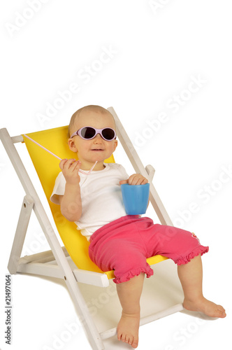 funny little girl in sunglasses on little yellow deck chair