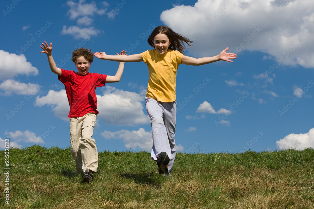 Girl and boy jumping, running against blue sky Girl and boy jumping, running against blue sky