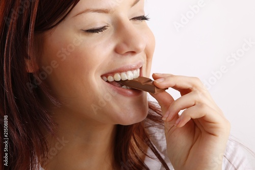 beautiful young woman with a bar of chocolate photo