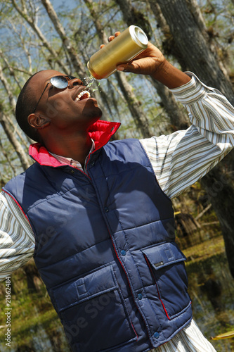 Young hiker enjoys a drink out of a can