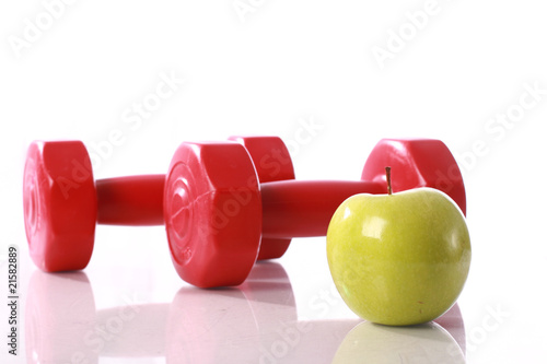 Green apple on the background of dumbbells.
