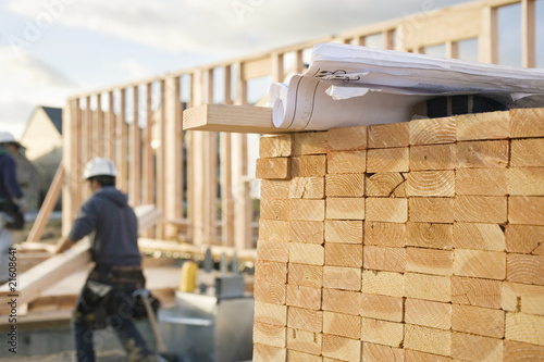 Stacked Lumber and Blueprints at a Construction Site