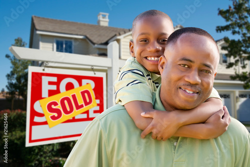 Father and Son In Front of Real Estate Sign and Home