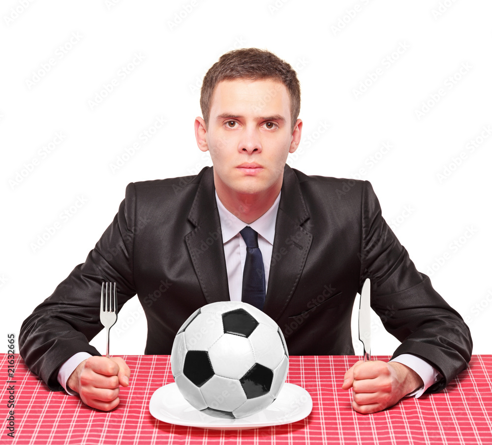 A businessman sited on a table with a ball in his plate A businessman sited on a table with a ball in his plate