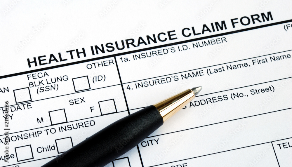 Filling the health insurance claim form with a pen Filling the health insurance claim form with a pen