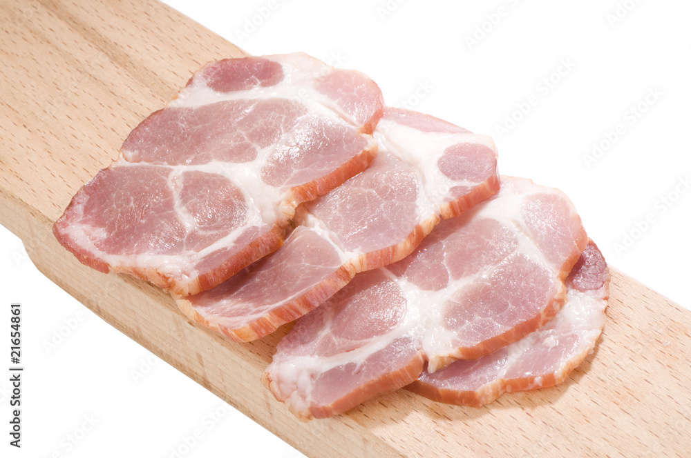 Sliced cooked pork neck on a cutting board isolated on white