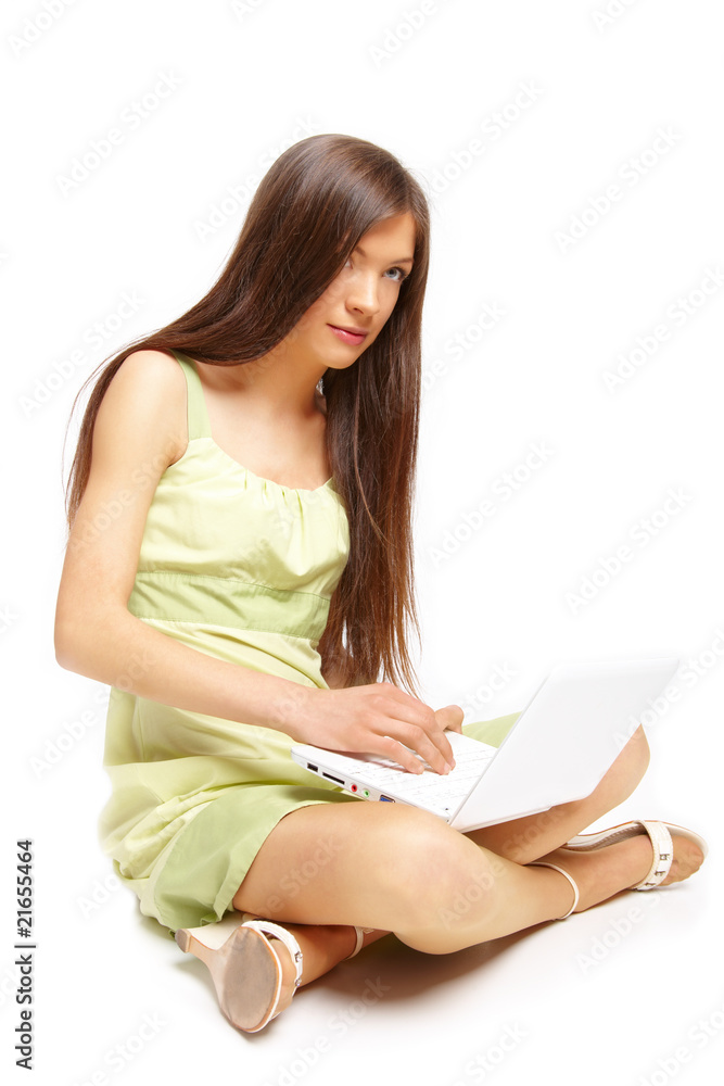 Foto de Beautiful young girl sitting cross legs on the floor using a lap do  Stock | Adobe Stock