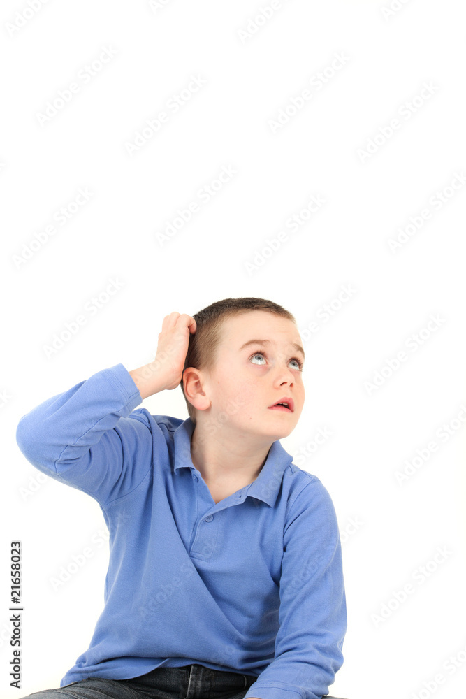 Young boy looking up and scratching head Young boy looking up and scratching head