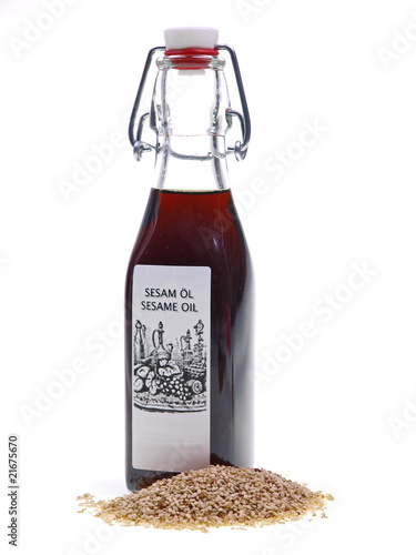 flasche sesamöl mit sesamsaate auf weißem hintergrund 	 photo