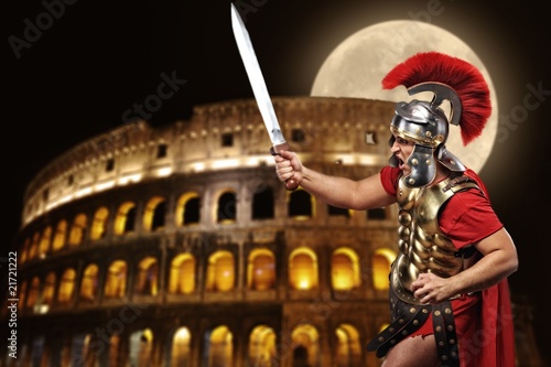 Roman legionary soldier in front of coliseum at night time photo