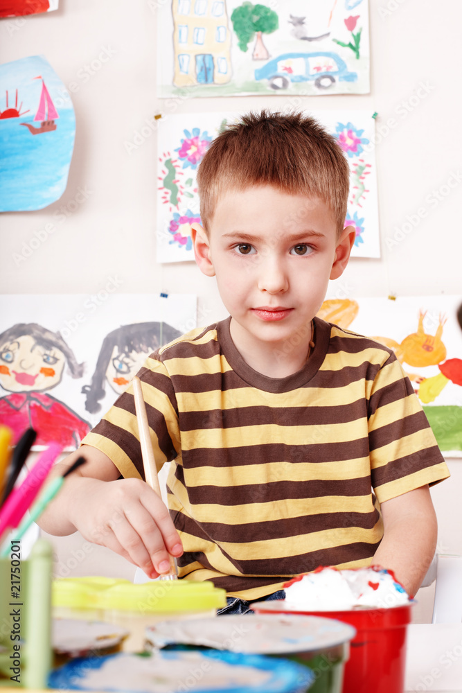 Child with picture and brush in play room. Child with picture and brush in play room.