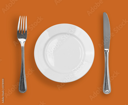 Knife, plate and fork on color background