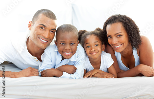 Happy family having fun lying down on bed