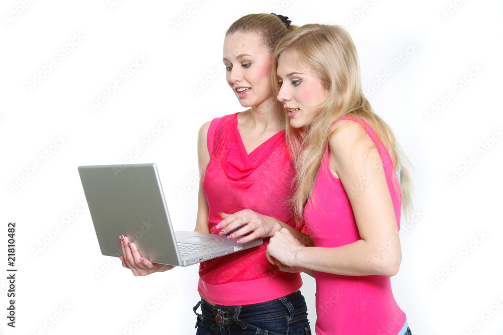 two young attractive girls with laptop over white two young attractive girls with laptop over white
