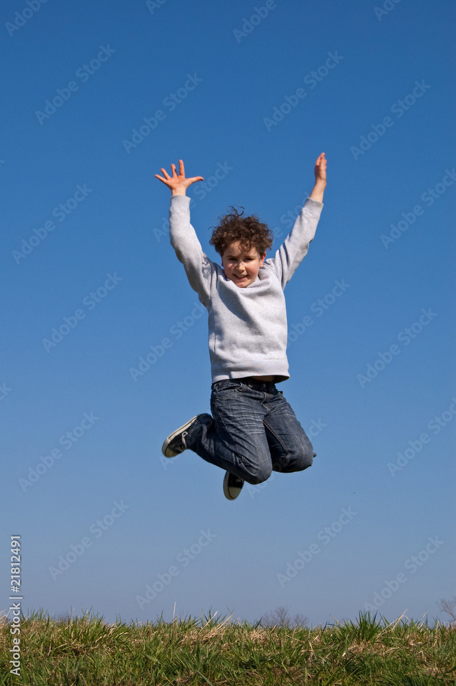 Boy jumping, running against blue sky Boy jumping, running against blue sky