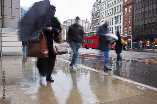 Busy london commuters in the pouring rain