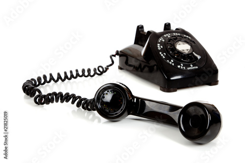 A vintage black telephone on a white background
