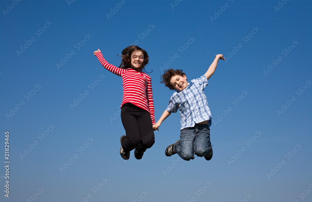 Girl and boy jumping, running against blue sky Girl and boy jumping, running against blue sky