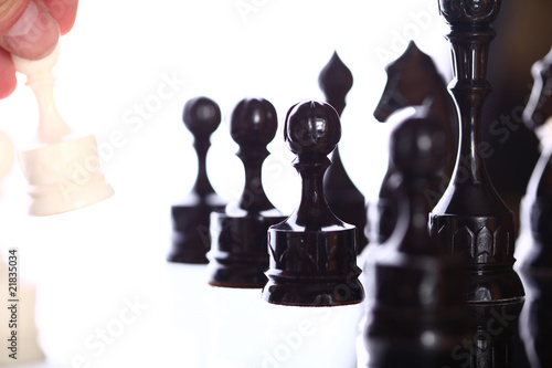 chessplayer making a move on white background. photo