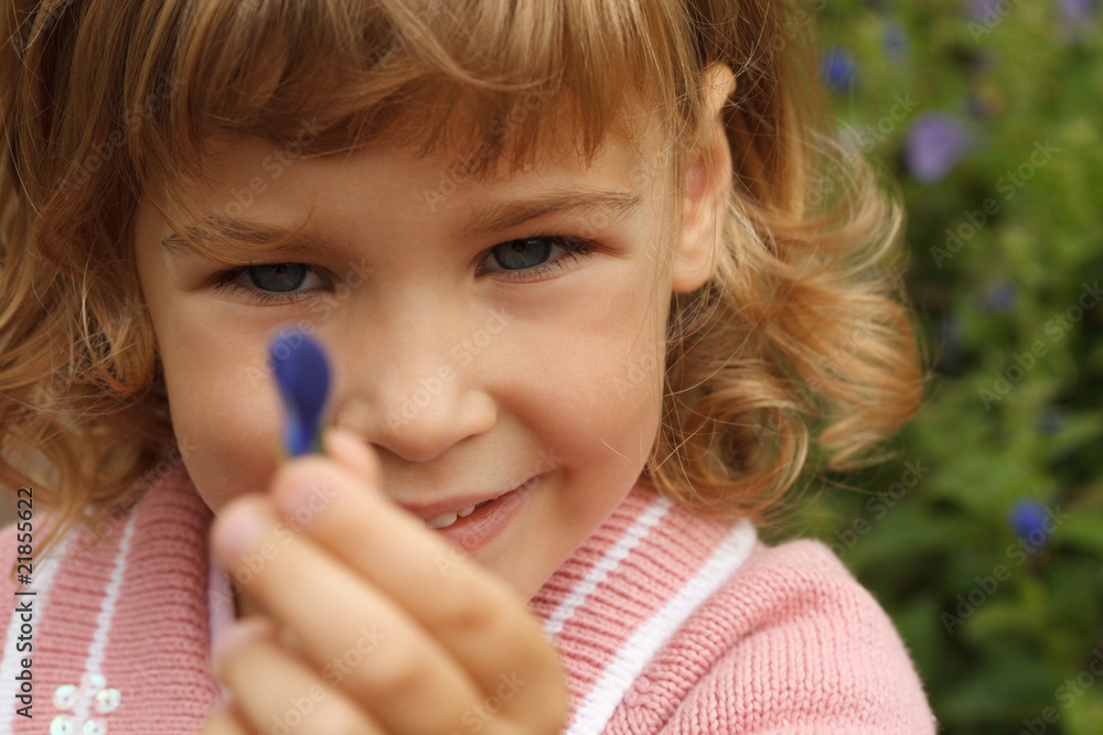 girl holding in hand annual delphinium, around flowers area girl holding in hand annual delphinium, around flowers area