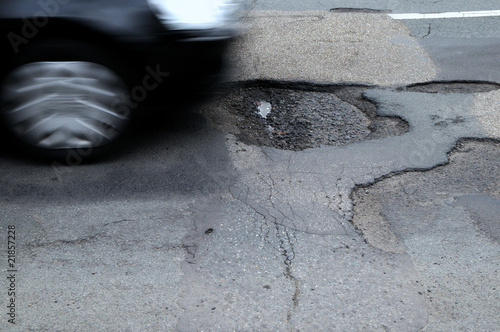 pothole in a road with car