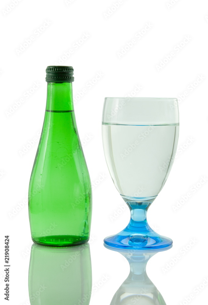 Bottle and glass of mineral water reflected on white background