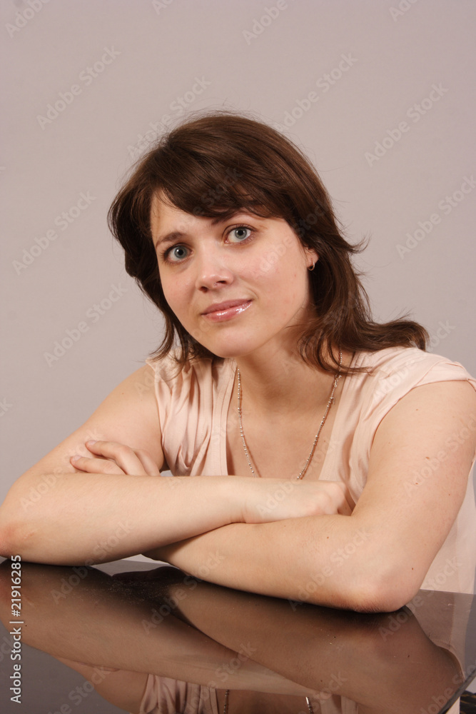 a young woman sitting at a glass table a young woman sitting at a glass table