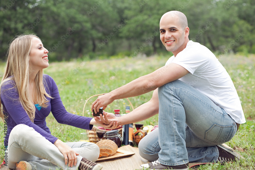 Couple sitting in blanket smiling with picnic mode Couple sitting in blanket smiling with picnic mode