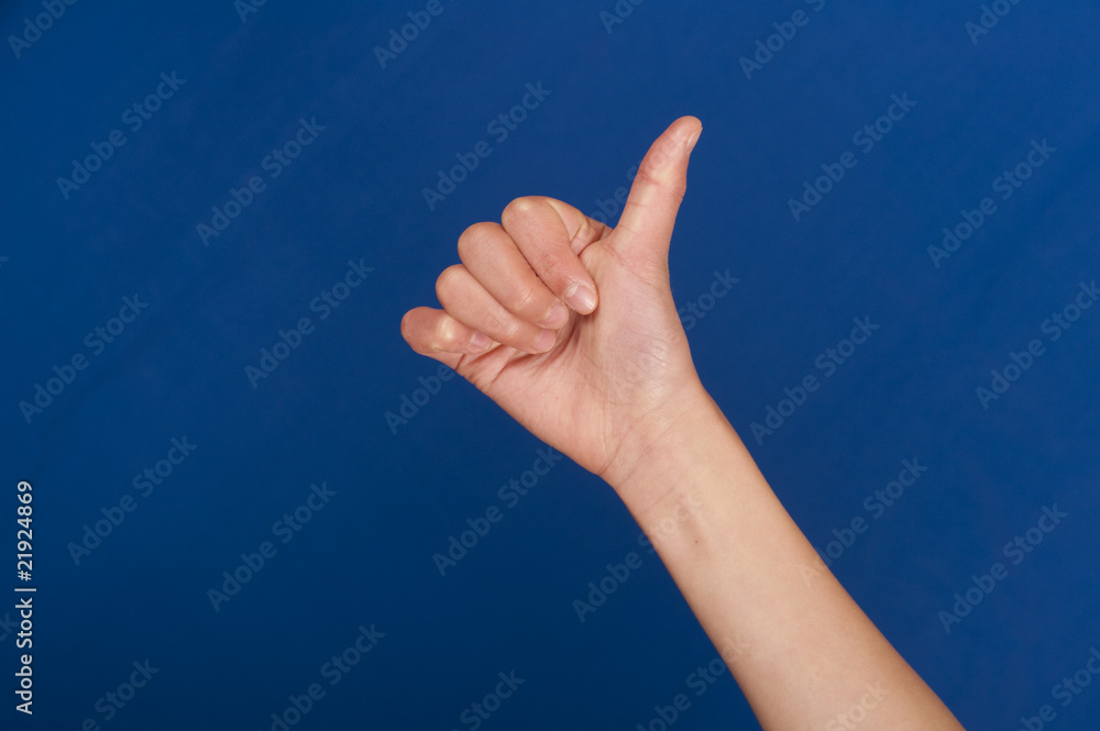 handshot of hand doing thumbs up against blue background handshot of hand doing thumbs up against blue background