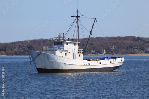 Old rusty fishing boat anchored in a protected harbor