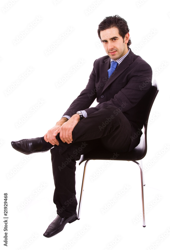 Young businessman sitting on chair, against white background Young businessman sitting on chair, against white background