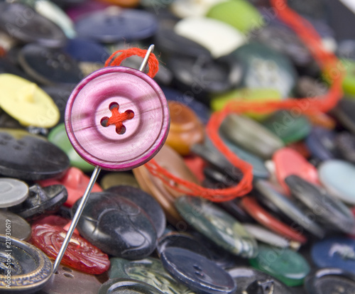 Sewing needle with buttons on background photo