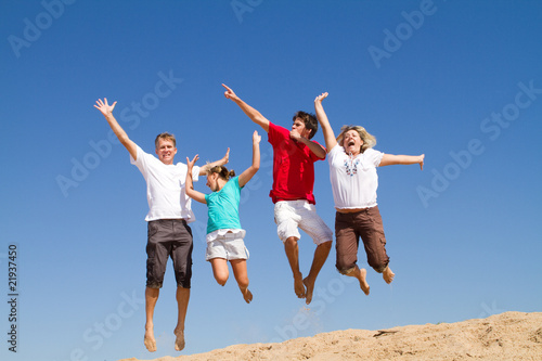 active family jumping on beach