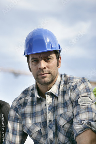 Portrait d'un ouvrier portant un casque de chantier bleu