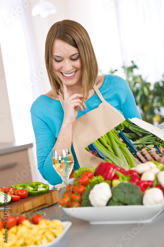 Cooking - Smiling woman holding coobook  with vegetable and past