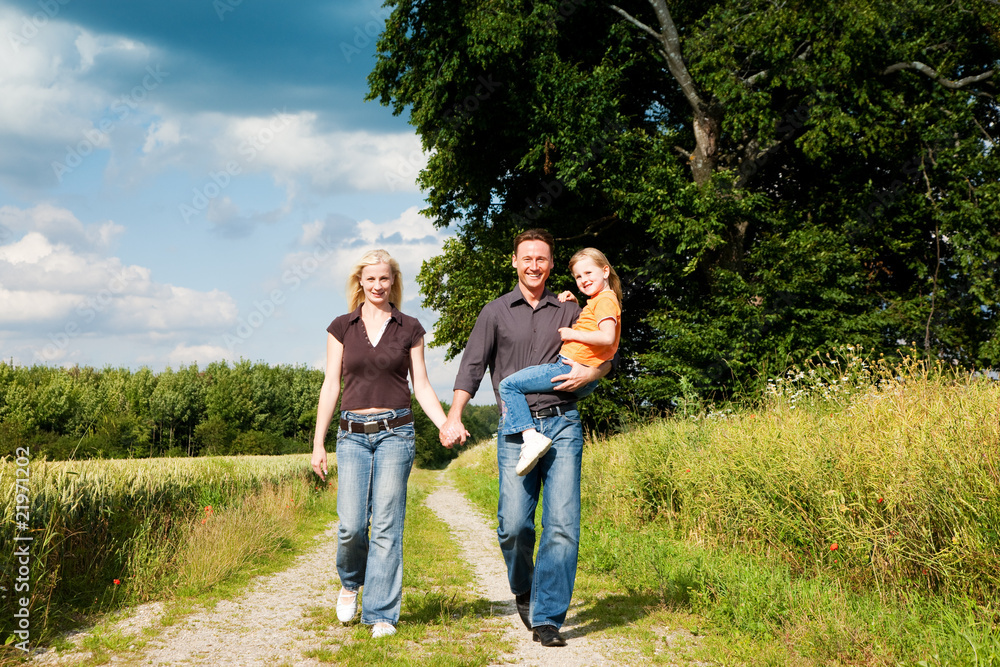 Family having a walk carrying child