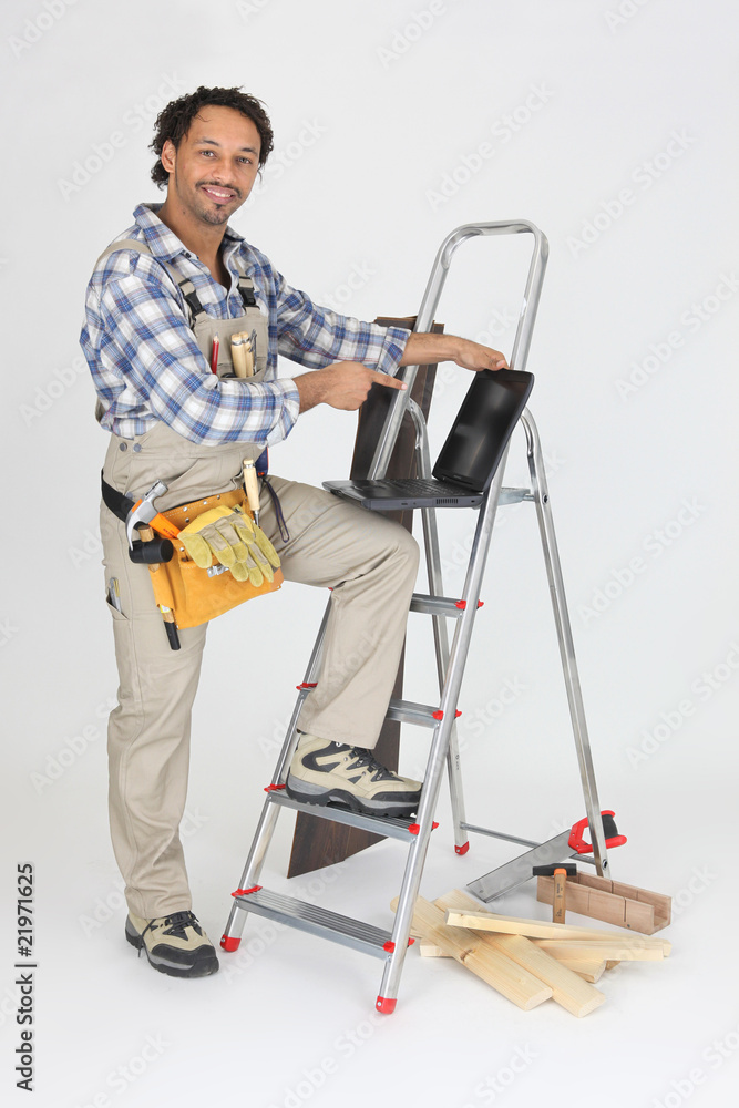 Menuisier debout devant un ordinateur portable Menuisier debout devant un ordinateur portable
