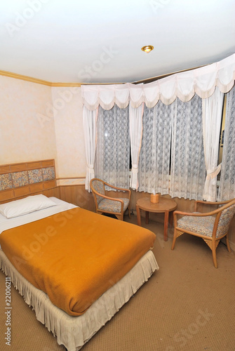 Single bed in modern hotel room with table and chairs