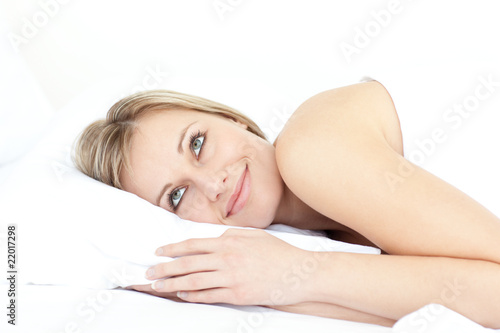 Delighted woman relaxing on her bed