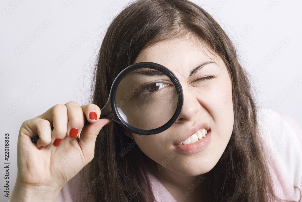 pretty young woman looking through magnifying pretty young woman looking through magnifying