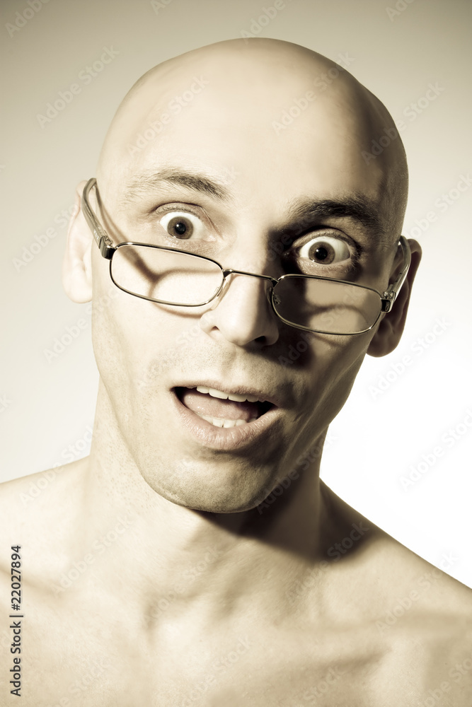 Shocked man looking over the top of his reading glasses Shocked man looking over the top of his reading glasses