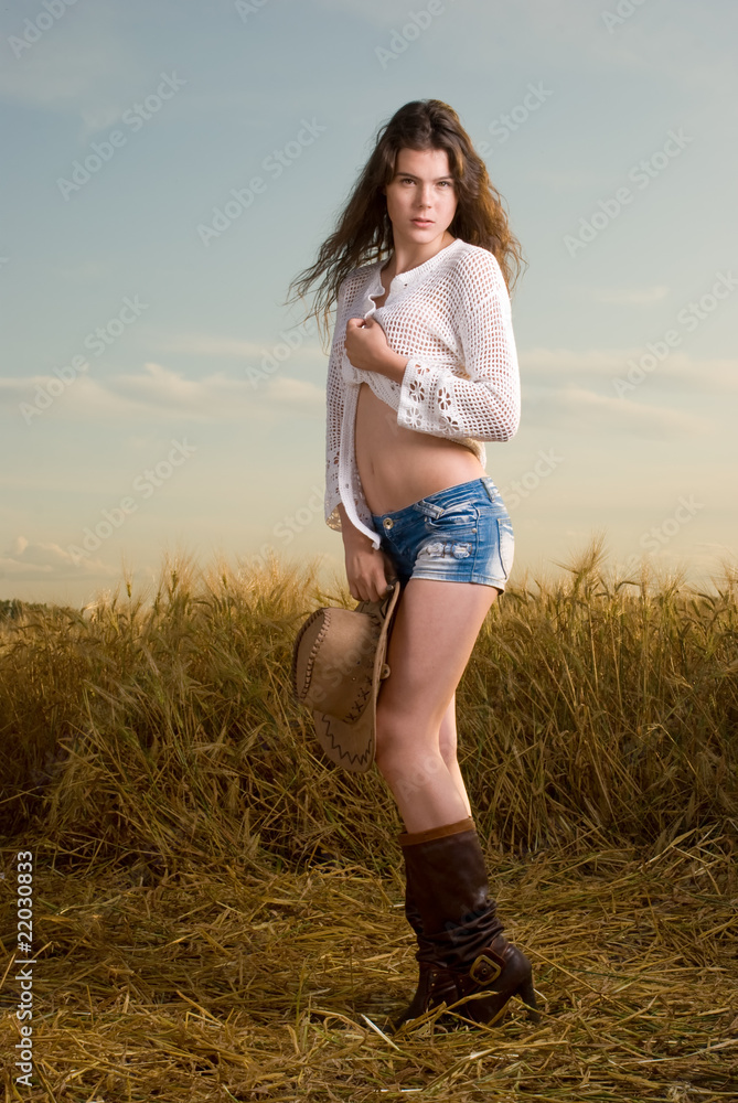 Beautiful slavonic girl in cowboy clothes pose in wheat field Beautiful slavonic girl in cowboy clothes pose in wheat field
