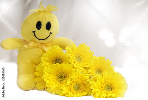 A happy smiley toy with yellow flowers