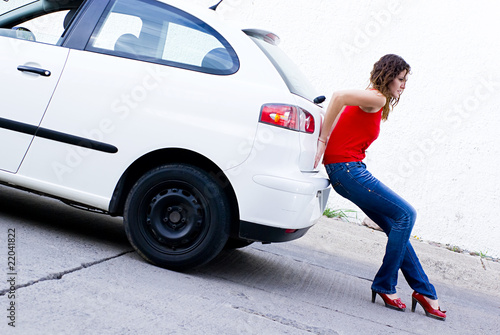 woman pushing car out of gasoline photo