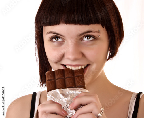 Young beautiful glutton eat chocolate isolated on white