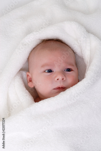 bébé emmitouflé dans un essuie éponge blanc