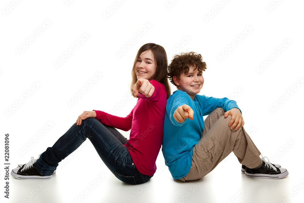 Girl and boy sitting and pointing Girl and boy sitting and pointing